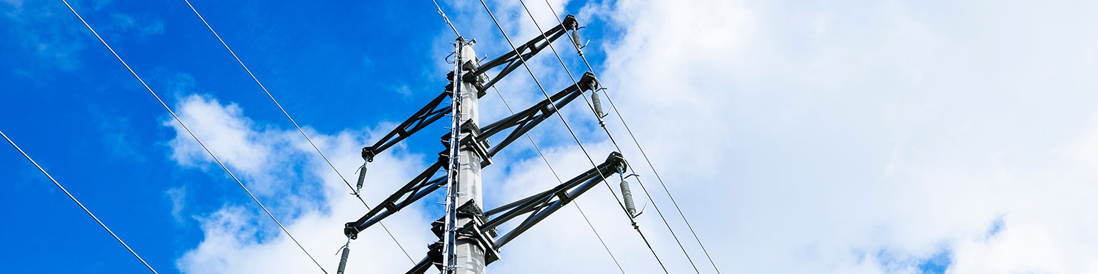 high-voltage line in front of blue sky and clouds