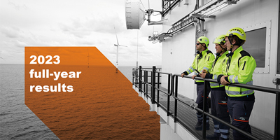 three technicians with safety protection equipment looking at the see from a offshore platform next to wind turbines plus banner saying 2023 full-year results